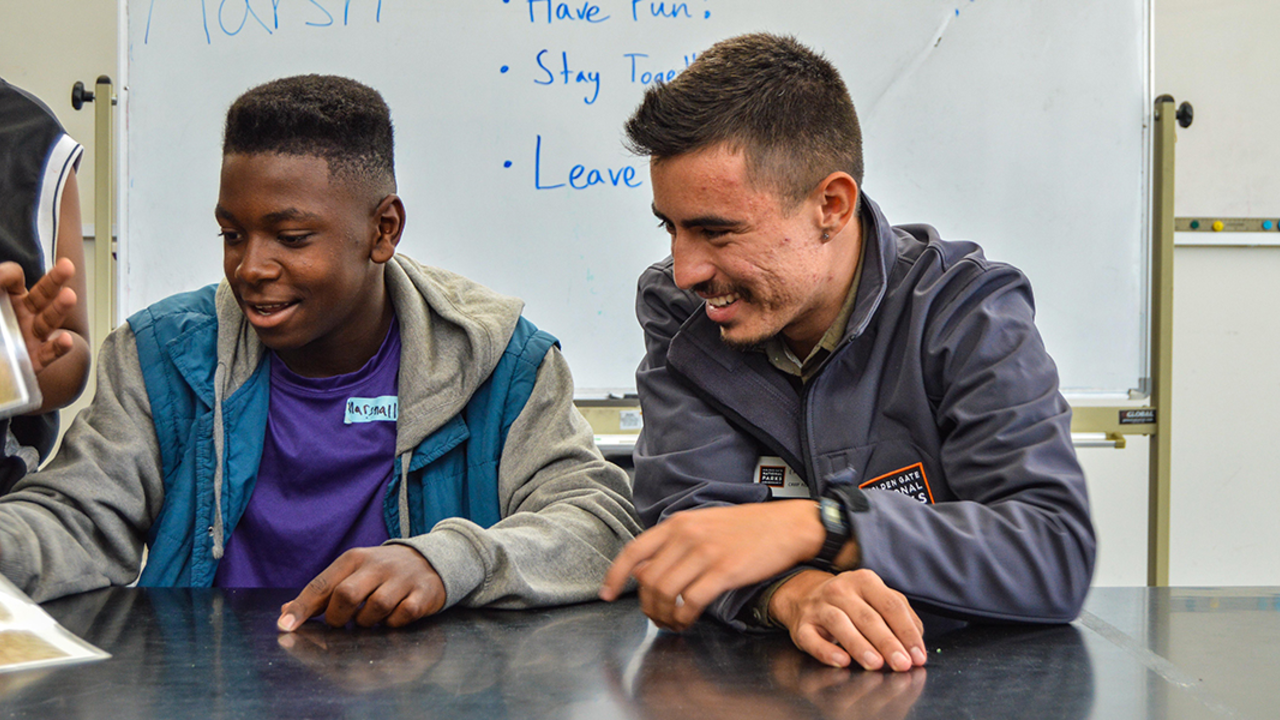 Reviewing Marsh Pictures A Crissy Field Center educator a teenage youth look over images inside the Crissy Field Center facility