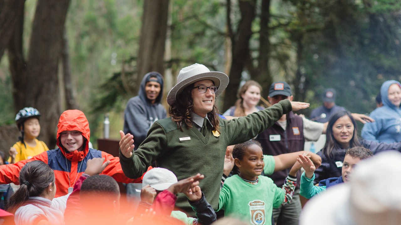 Telling a story with kids A National Park Service Ranger leads a large group of smiling children in an interactive story