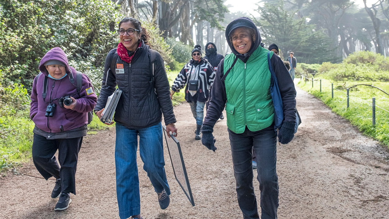 A group of people walking down a path at Lands End in San Francisco. A group of people walking down a path at Lands End in San Francisco.