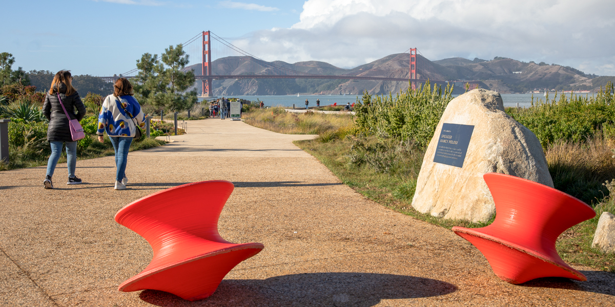 People walking a path in the Presidio Tunnel Tops with the Golden Gate Bridge viewed in the background.