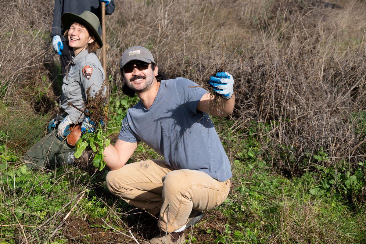 A volunteer strikes a pose while helping to restore Tennessee Valley.