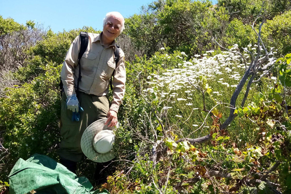 A volunteer poses with vegetation in Tennessee Valley.