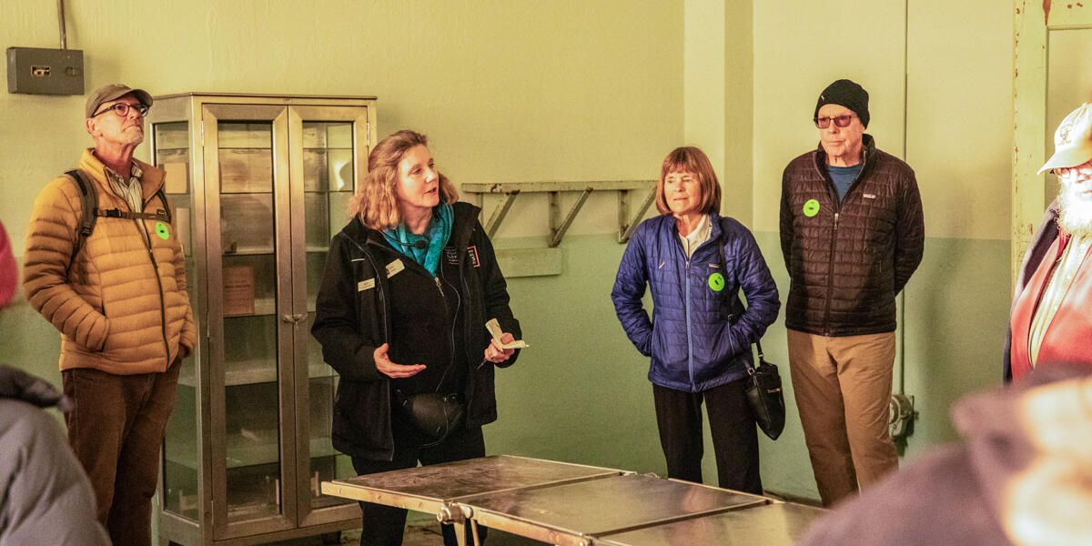A guide leads a tour group through the medical wing during a behind-the-scenes tour at Alcatraz Island