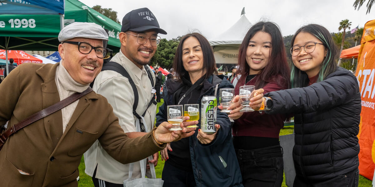 A group of people putting together their Parks4All: Brewfest glasses to cheers for the camera.