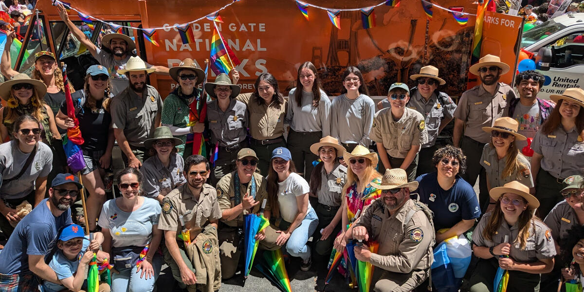 A group photo of all the Parks Conservancy staff and NPS rangers that participated in the parade in front of the Roving Ranger.