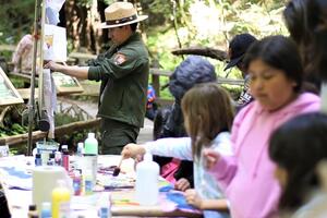 NPS Ranger hangs up watercolor art.