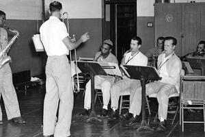 A historic black-and-white photograph of a group of incarcerated musicians at Alcatraz Island playing in a prison band. 