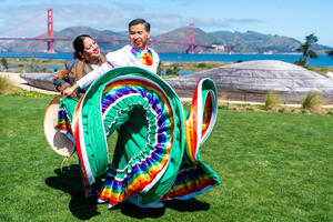 Two dancers performing at Presidio Tunnel Tops with a golden gate bridge view.