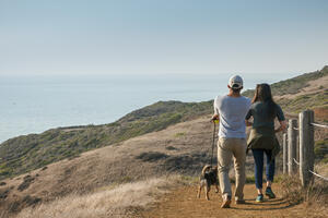 Couple and dog walking along Milagra Ridge