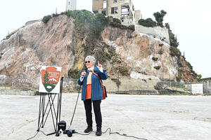 Jolene Babyak stands on the parade grounds on Alcatraz Island in front of reporters.