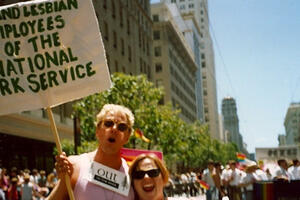 An NPS ranger holds a sign that says "Gay and Lesbian Employees of the National Park Service" in the San Francisco Pride Parade.