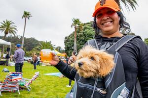 A woman poses with her dog at the Parks4All: Brewfest in the Presidio.