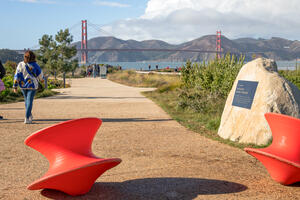 People walking a path in the Presidio Tunnel Tops with the Golden Gate Bridge viewed in the background.