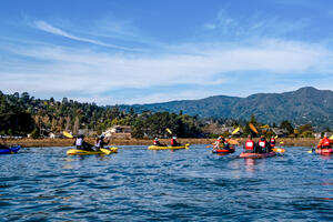 A group Kayaking at Bothin Marsh in Marin, with Mount Tamalpais in the background.