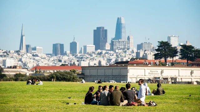Park visitors enjoy a picnic sitting on the lawn at Crissy Field amongst the San