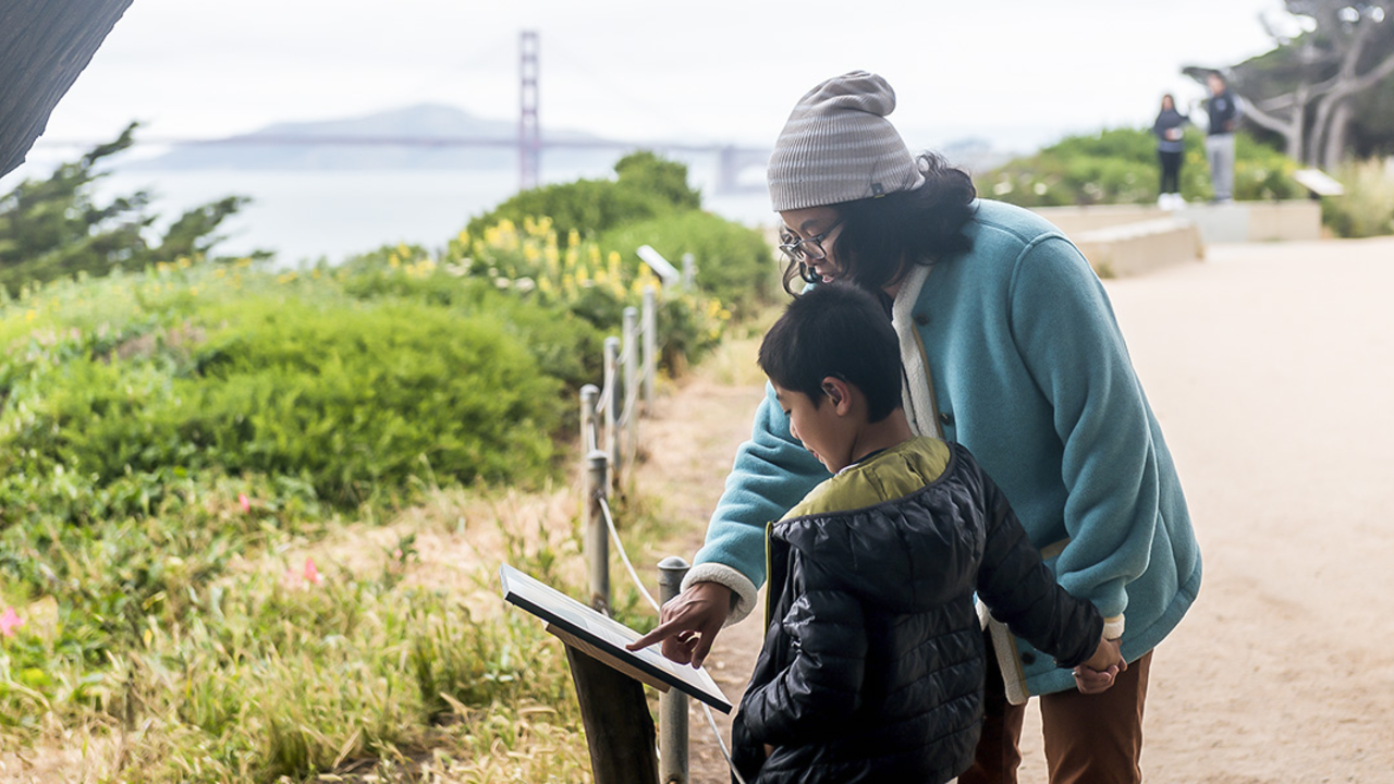 A family checks out a StoryWalk at Lands End in San Francisco. A family checks out a StoryWalk at Lands End in San Francisco.