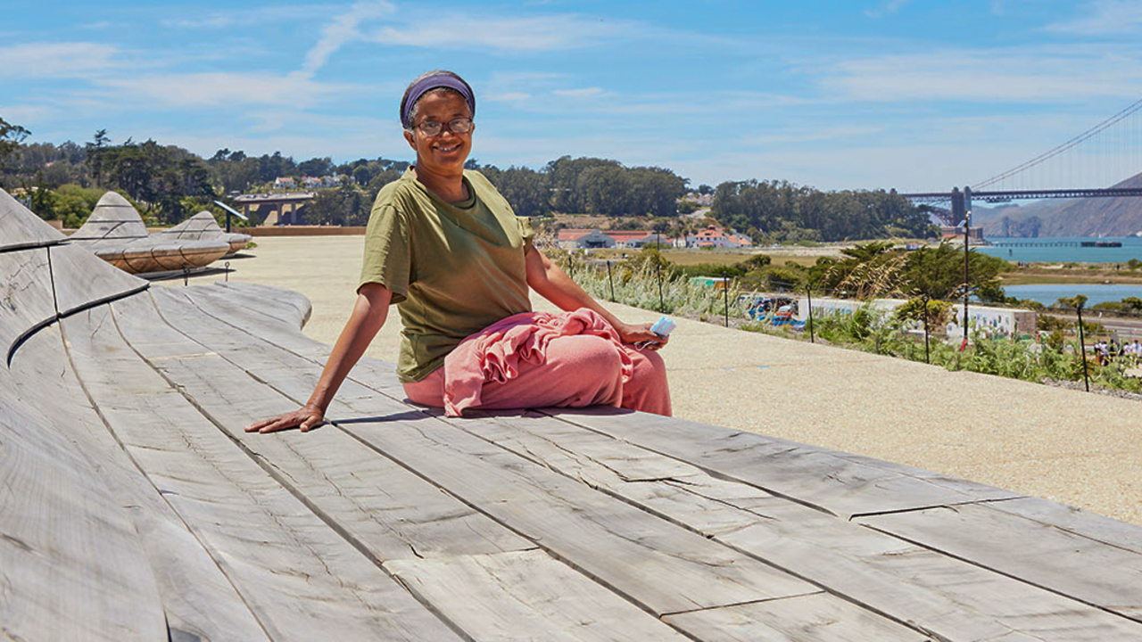 Person sits on cypress wood benches at Presidio Tunnel Tops. Person sits on cypress wood benches at Presidio Tunnel Tops.