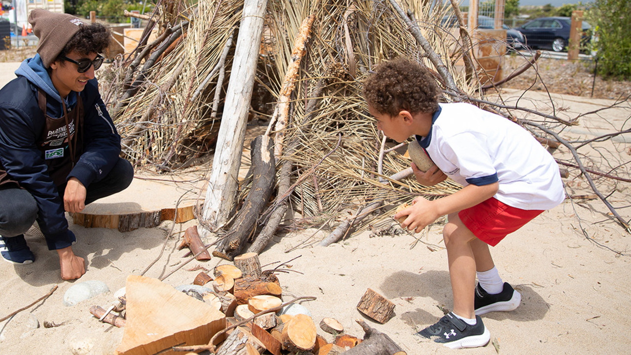 An Adventure Guide engages with a young person at the Outpost at Presidio Tunnel Tops. An Adventure Guide engages with a young person at the Outpost at Presidio Tunnel Tops.