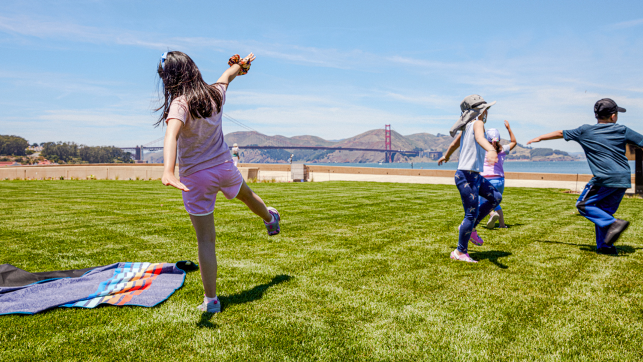 Kids play at the Golden Gate Meadow Kids stretch and play, running around the Presidio Tunnel Tops lawn.