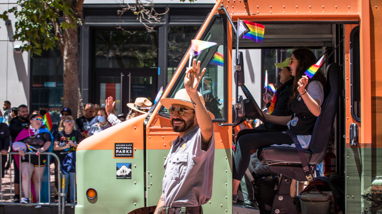 NPS rangers march alongside the Roving Ranger. NPS park ranger marches alongside the Roving Ranger mobile trailhead at the 2022 SF Pride parade.