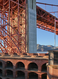 Golden Gate Bridge and Fort Point Historic Site View of the Golden Gate Bridge and the top of Fort Point National Historic Site set against a blue sky