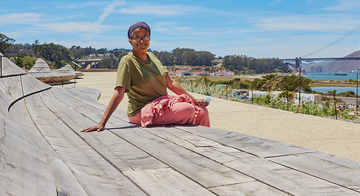 Person sits on cypress wood benches at Presidio Tunnel Tops. Person sits on cypress wood benches at Presidio Tunnel Tops.