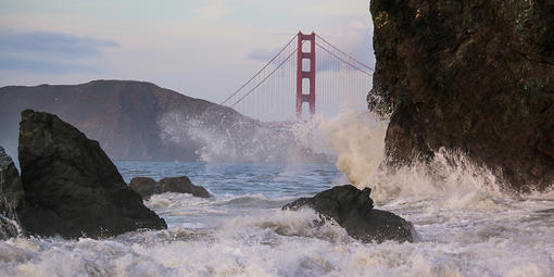 Waves crash before the Golden Gate Bridge