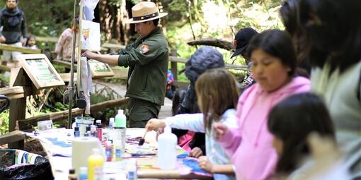 NPS Ranger hangs up watercolor art.