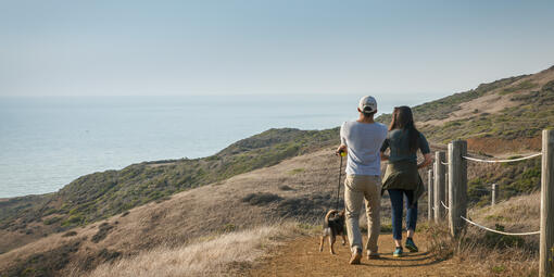 Couple and dog walking along Milagra Ridge