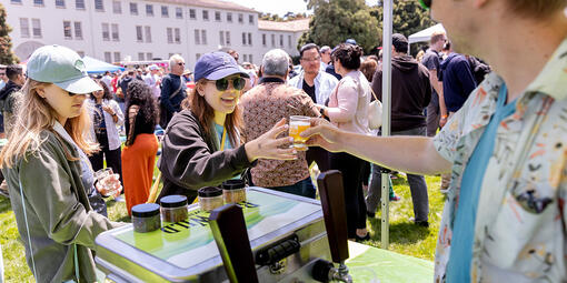 Buck Wild Brewing hands event attendee a tasting glass full of beer at Parks4All: Brewfest, a beer festival and fundraiser, on Saturday, July 29th, 2023 in the Presidio of San Francisco.