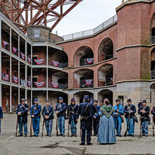 People gathered at Fort Point National Historic Site on Living History Day, dressed in civil war era union uniforms for reenactment.