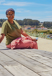 Person sits on cypress wood benches at Presidio Tunnel Tops. Person sits on cypress wood benches at Presidio Tunnel Tops.